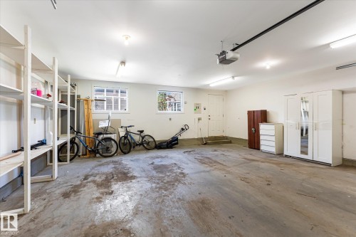 Spacious garage featuring concrete flooring and exposed ceiling beams - 4317 152 Avenue Nw, Edmonton, AB - Indoor Photo Showing Garage