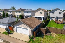 Detached two-car garage with a panel garage door and shingle roofing - 