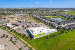 Modern commercial building featuring a large parking area, expansive green spaces, and a prominent street-front presence - 