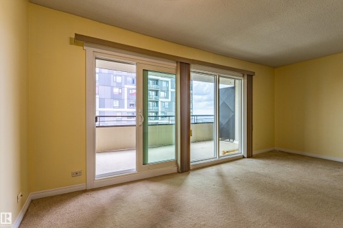 Spacious room with light yellow walls and textured carpet flooring - #1210 10140 120 St Nw, Edmonton, AB - Indoor Photo Showing Other Room