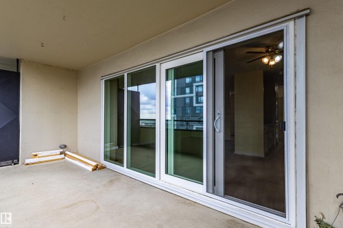 Concrete balcony featuring multi-panel sliding glass doors with white frames - #1210 10140 120 St Nw, Edmonton, AB - Outdoor With Deck Patio Veranda With Exterior