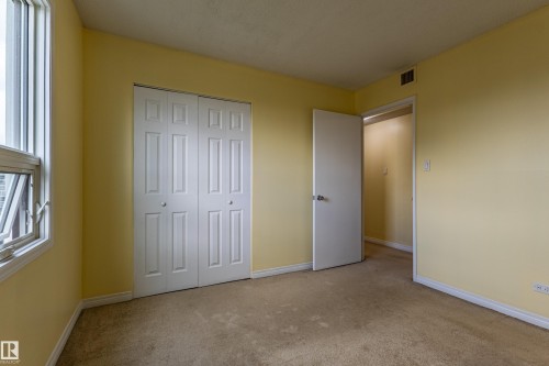 Interior room featuring light yellow walls and carpeted flooring - #1210 10140 120 St Nw, Edmonton, AB - Indoor Photo Showing Other Room