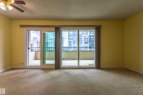 Room featuring expansive sliding glass doors opening to a private balcony - #1210 10140 120 St Nw, Edmonton, AB - Indoor Photo Showing Other Room
