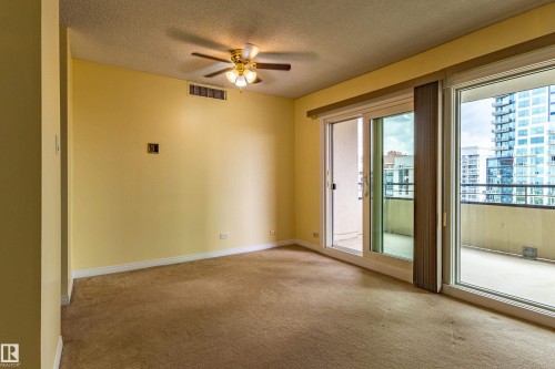 Living area featuring neutral carpeting and light-toned walls - #1210 10140 120 St Nw, Edmonton, AB - Indoor Photo Showing Other Room