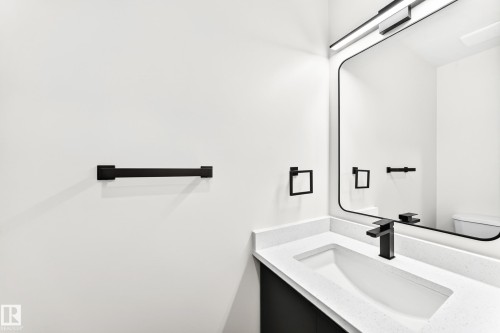 Modern bathroom vanity with integrated white sink, quartz-finish countertop, and matte black faucet - 3119 144 Avenue Nw, Edmonton, AB - Indoor Photo Showing Bathroom