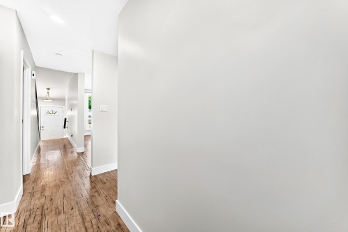 Bright hallway featuring wood-finish flooring and white baseboards - 3119 144 Avenue Nw, Edmonton, AB - Indoor Photo Showing Other Room