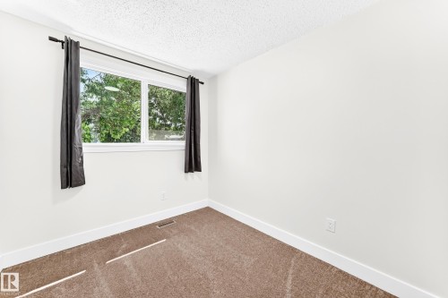 White-painted room featuring a double-paned window with dark drapery - 3119 144 Avenue Nw, Edmonton, AB - Indoor Photo Showing Other Room