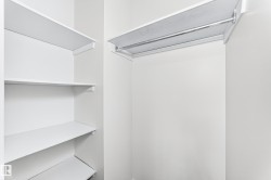 Built-in closet system featuring multiple white shelving units and a chrome hanging rod - 