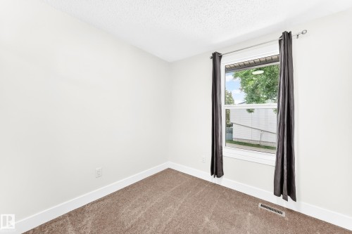 Carpeted room featuring a single window with white trim, a floor vent, and a textured white ceiling - 3119 144 Avenue Nw, Edmonton, AB - Indoor Photo Showing Other Room