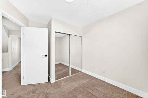 Room featuring neutral wall tones, textured carpet, and a flush-mount ceiling light - 3119 144 Avenue Nw, Edmonton, AB - Indoor Photo Showing Other Room