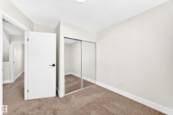 Room featuring neutral wall tones, textured carpet, and a flush-mount ceiling light - 
