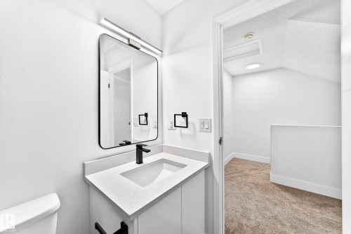 Modern vanity featuring a white quartz countertop with an integrated sink and matte black faucet - 3119 144 Avenue Nw, Edmonton, AB - Indoor