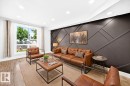 Living area featuring an accent wall with geometric paneling, wood-finish flooring, recessed lighting, and a large window - 3119 144 Avenue Nw, Edmonton, AB  - Indoor Photo Showing Living Room 
