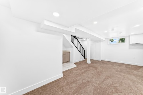 Finished lower level with recessed lighting, brown carpet flooring, and a window for natural light - 3119 144 Avenue Nw, Edmonton, AB - Indoor Photo Showing Other Room