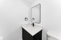 Modern vanity with a white countertop and integrated sink, matte black faucet, and coordinating black-framed mirror - 