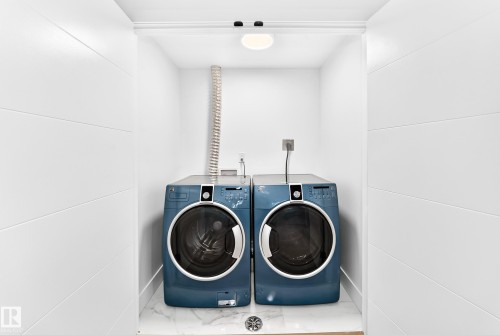 Compact laundry alcove featuring white shiplap walls and a tile floor - 3119 144 Avenue Nw, Edmonton, AB - Indoor Photo Showing Laundry Room