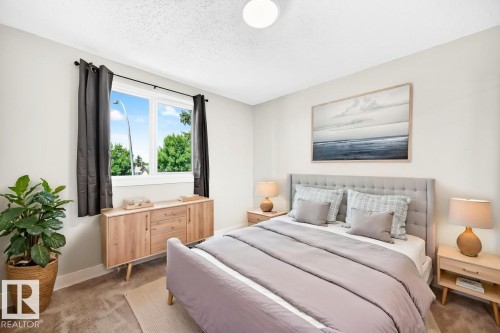 Spacious bedroom featuring light neutral walls and textured carpeting - 3119 144 Avenue Nw, Edmonton, AB - Indoor Photo Showing Bedroom
