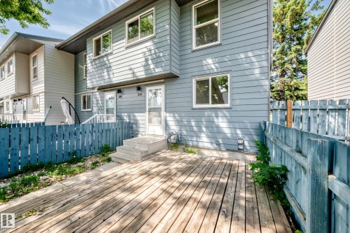 Expansive wood deck with a blue picket fence and concrete steps - 3119 144 Avenue Nw, Edmonton, AB - Outdoor With Deck Patio Veranda