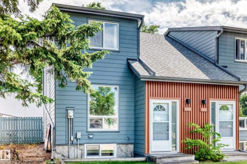 Contemporary exterior featuring blue horizontal siding and vertical wood-look accent panels - 3119 144 Avenue Nw, Edmonton, AB - Outdoor