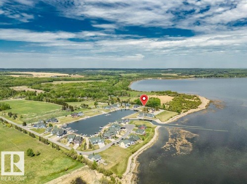 Waterfront community featuring a private marina with multiple boat slips, immediate water access, and surrounding green spaces - 12 Sunset Harbour, Rural Wetaskiwin County, AB 