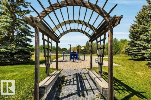 Wood pergola welcomes you to the well maintained playground - 12 Sunset Harbour, Rural Wetaskiwin County, AB 