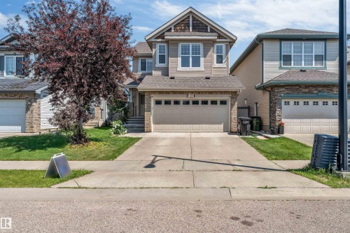 Two-story residence featuring light siding, a gabled roofline, and an attached two-car garage - 121 64 Street Sw, Edmonton, AB - Outdoor With Facade