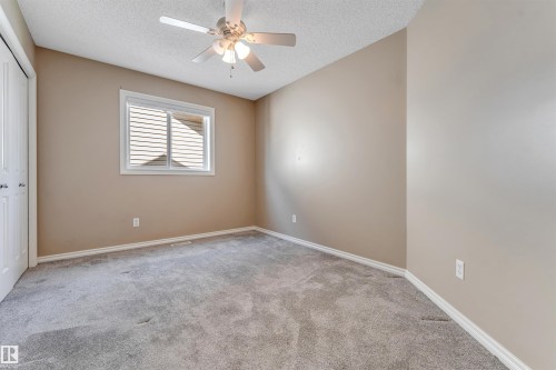 Neutral-toned room featuring a ceiling fan with integrated lighting, a window with horizontal blinds, gray carpet, and white trim - 121 64 Street Sw, Edmonton, AB - Indoor Photo Showing Other Room