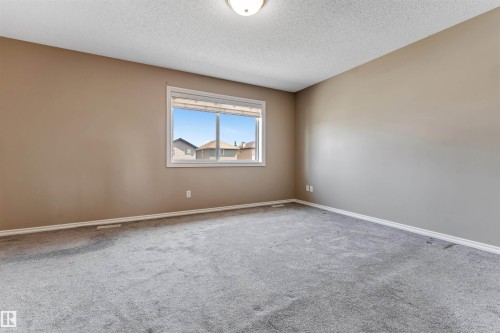 Room featuring a window with white trim, gray carpet, neutral wall paint, and white baseboards - 121 64 Street Sw, Edmonton, AB - Indoor Photo Showing Other Room