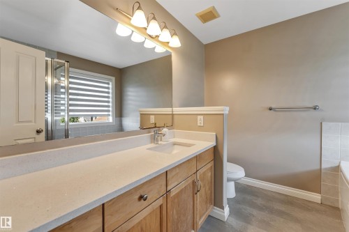 Bathroom featuring a light wood-finish double vanity with a light-toned countertop and dual integrated sinks - 121 64 Street Sw, Edmonton, AB - Indoor Photo Showing Bathroom