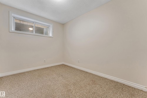 Light beige walls complement the neutral-toned carpet flooring - 121 64 Street Sw, Edmonton, AB - Indoor Photo Showing Other Room