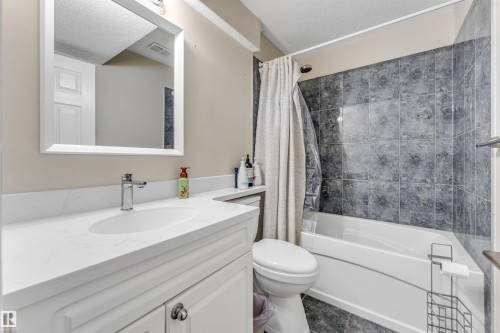 Bathroom featuring a white vanity with an integrated sink, polished chrome faucet, and coordinating mirror - 121 64 Street Sw, Edmonton, AB - Indoor Photo Showing Bathroom