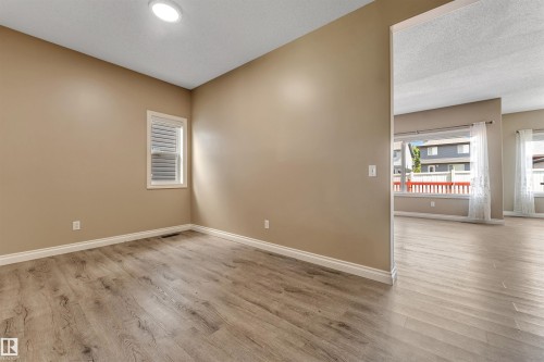 Room featuring wood-finish flooring, a window with horizontal blinds, and a flush-mount ceiling light - 121 64 Street Sw, Edmonton, AB - Indoor Photo Showing Other Room