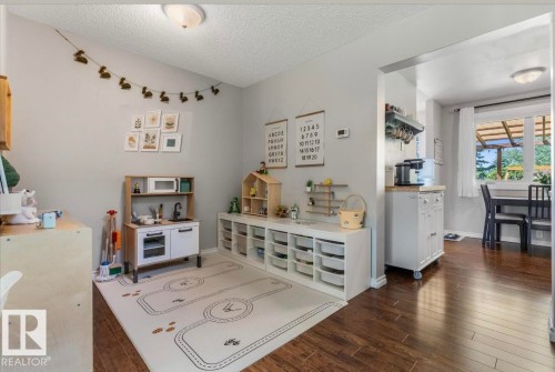 Hardwood-style flooring extends into an open concept dining area - 4718 35 Avenue Nw, Edmonton, AB - Indoor