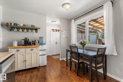 Bright dining area featuring wood-finish flooring, a large window, and light gray walls - 4718 35 Avenue Nw, Edmonton, AB - Indoor Photo Showing Dining Room
