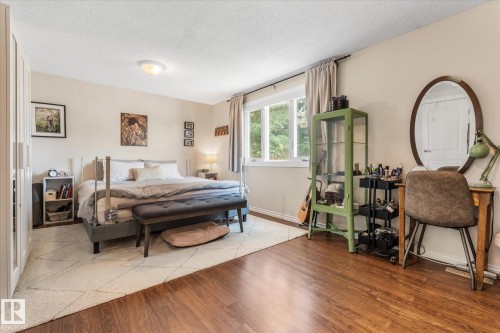 Bedroom featuring rich wood-finish flooring and a large window - 4718 35 Avenue Nw, Edmonton, AB - Indoor Photo Showing Bedroom