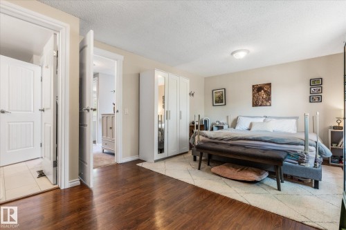 Rich wood-finish flooring complements light-toned walls and white trim - 4718 35 Avenue Nw, Edmonton, AB - Indoor Photo Showing Bedroom