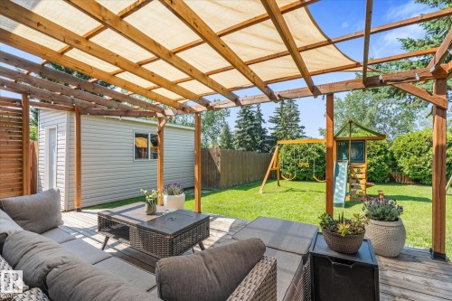 Expansive wood-finish deck with a pergola featuring a fabric canopy - 4718 35 Avenue Nw, Edmonton, AB - Outdoor With Deck Patio Veranda With Exterior