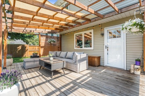 Expansive wood-finish deck featuring a slatted wood pergola with a canvas shade, exterior lighting, and a privacy screen - 4718 35 Avenue Nw, Edmonton, AB - Outdoor With Deck Patio Veranda With Exterior