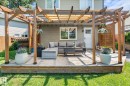 Expansive backyard featuring a lush lawn, mature evergreen trees, and a full privacy fence - 4718 35 Avenue Nw, Edmonton, AB  - Outdoor With Backyard 
