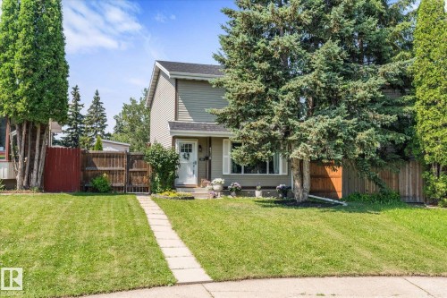Two-story residence featuring light green siding, a white front door with transom window, and a concrete pathway - 4718 35 Avenue Nw, Edmonton, AB - Outdoor