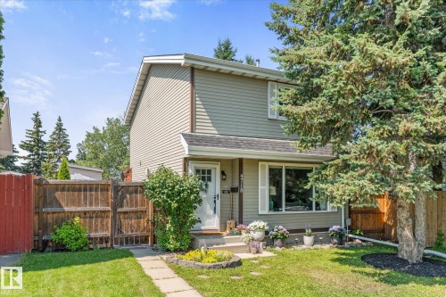 Two-story residence featuring light gray siding, a prominent front window with white shutters, and an inviting white entry door - 4718 35 Avenue Nw, Edmonton, AB - Outdoor