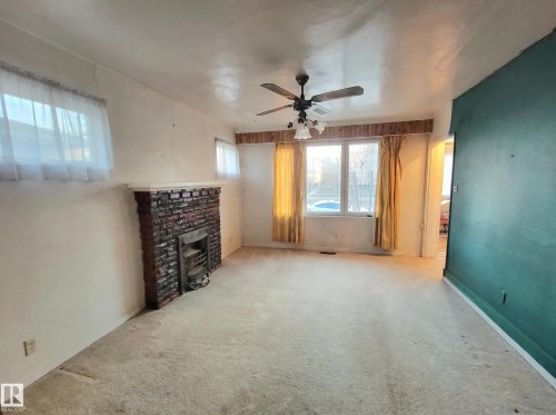 These photos are virtually decluttered to illustrate the clean, open space available to you once the current items are removed - 11405 97 Street Nw, Edmonton, AB - Indoor Photo Showing Other Room With Fireplace