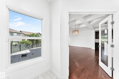 White-framed window overlooking a dark-stained deck with black railings - 1663 Rutherford Road Sw, Edmonton, AB - Indoor Photo Showing Other Room