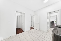 Utility area featuring white tile flooring and multiple entryways - 