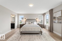 Spacious room featuring wood-finish flooring, light gray wall paint, and multiple windows with white blinds - 