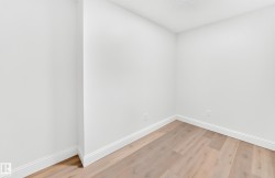 Room featuring light wood-finish flooring, crisp white walls, and bright white baseboards - 