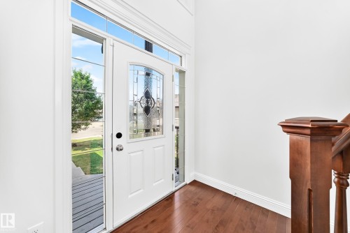 Entryway featuring a white door with decorative glass, sidelight windows, and a transom window - 1663 Rutherford Road Sw, Edmonton, AB - Indoor Photo Showing Other Room