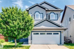 Two-story home featuring light grey siding with dark grey trim accents, a two-car garage with frosted pane windows, and arched windows on the upper level - 