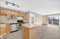 Kitchen and living area featuring wood-finish flooring - 