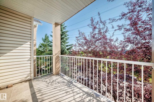 Exterior balcony featuring a concrete floor, white metal railing, and tan siding - #317 245 Edwards Dr Sw, Edmonton, AB - Outdoor With Balcony With Exterior